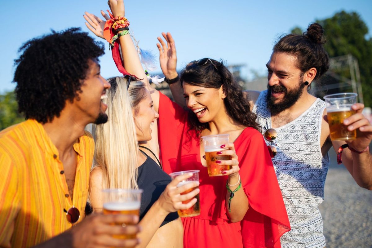 group of friends with drinks at festival